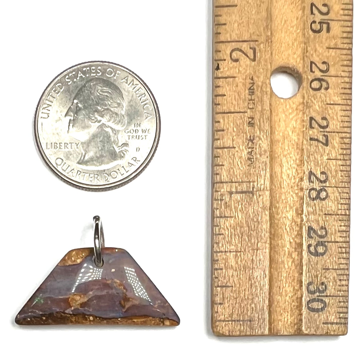 A drilled boulder opal stone with a sterling silver ring through the hole to be worn as a pendant.