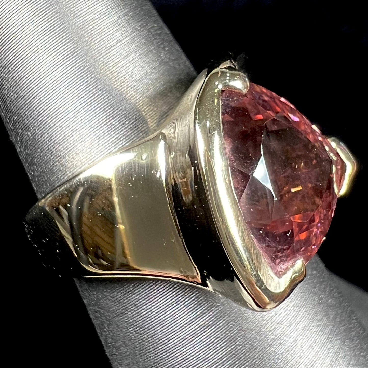 A unisex, yellow gold, trillion cut pink tourmaline solitaire ring.