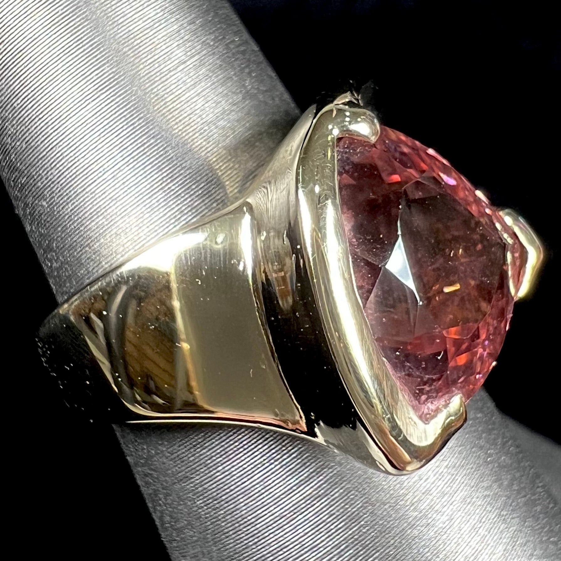 A unisex, yellow gold, trillion cut pink tourmaline solitaire ring.