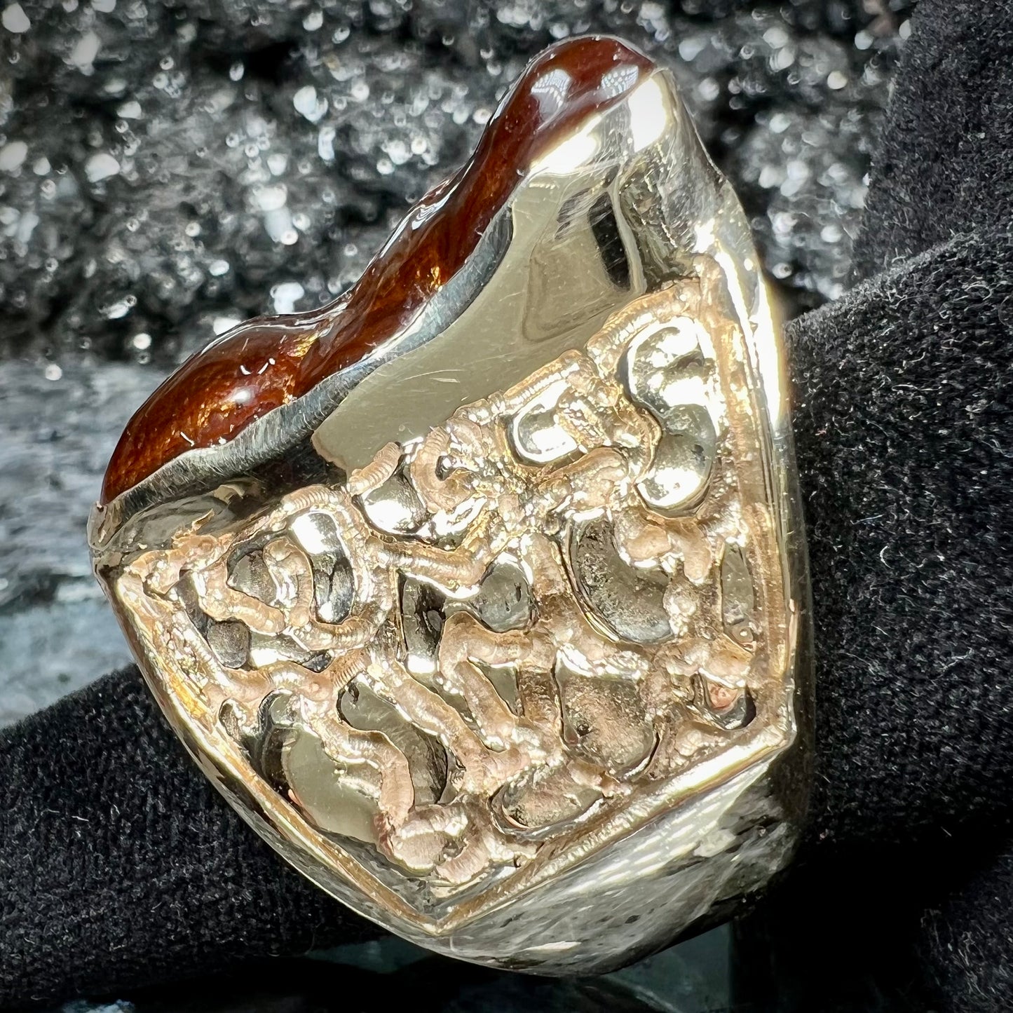 A large nugget style men's fire agate ring cast in yellow gold.  The fire agate is predominantly orange and green.