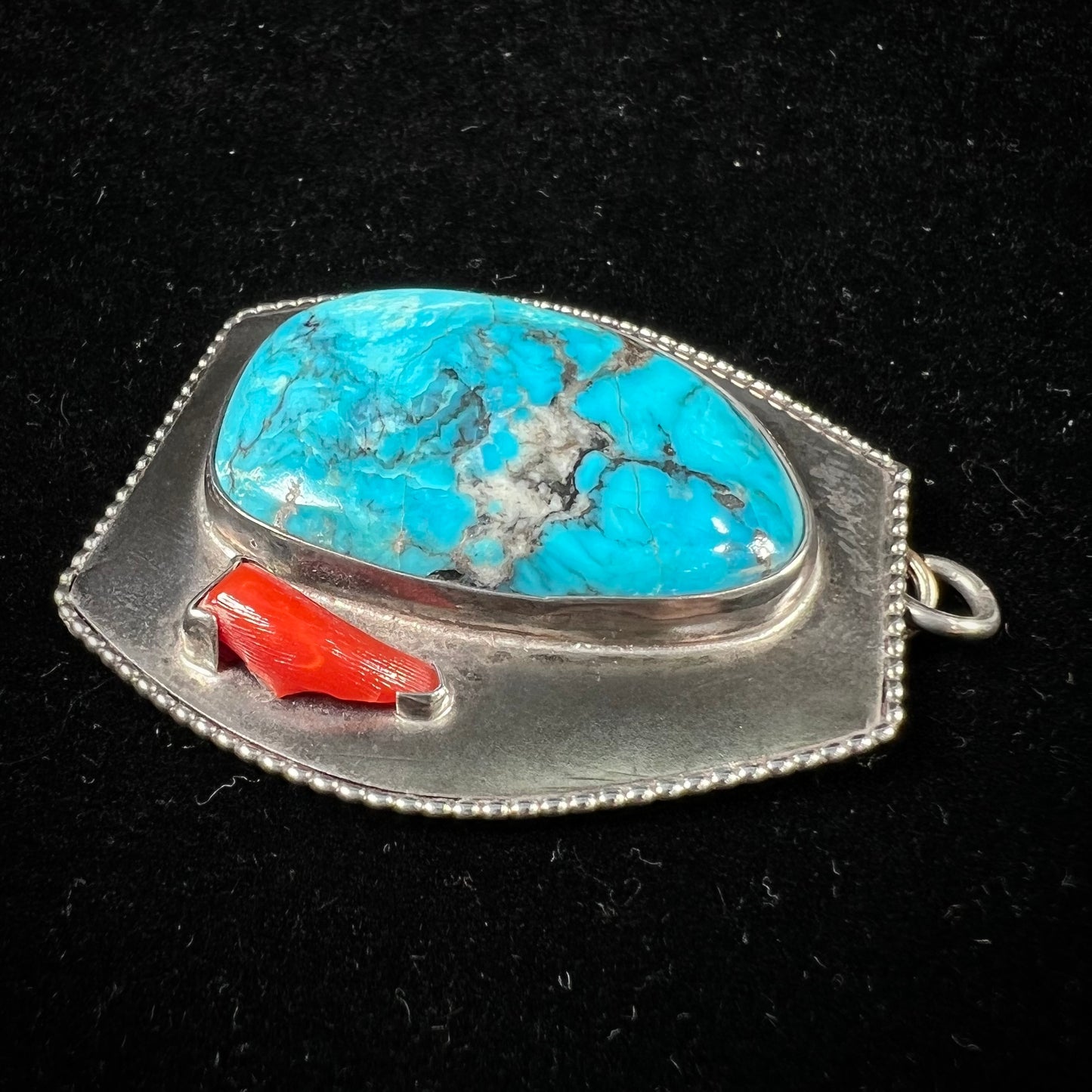 A sterling silver turquoise and polished coral branch pendant. The back of the piece is signed "A.H."