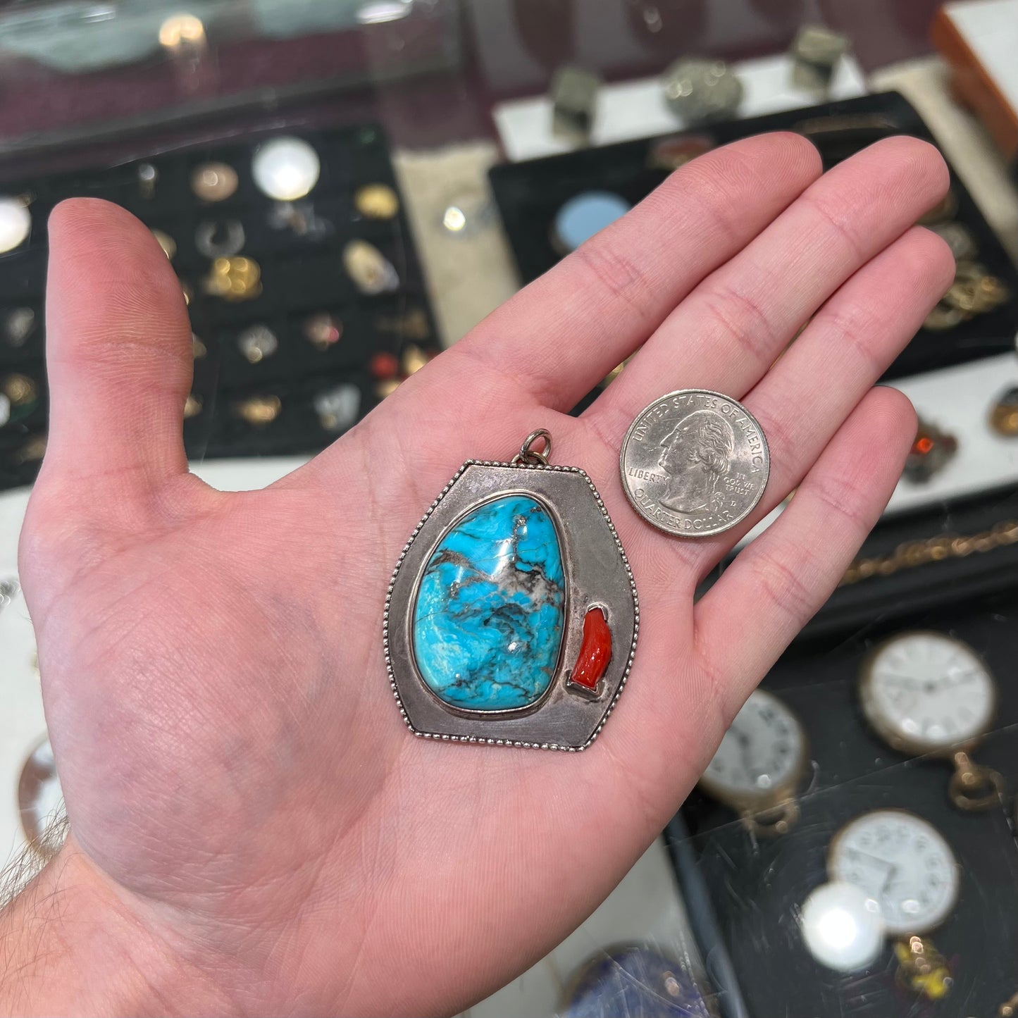 A sterling silver turquoise and polished coral branch pendant. The back of the piece is signed "A.H."