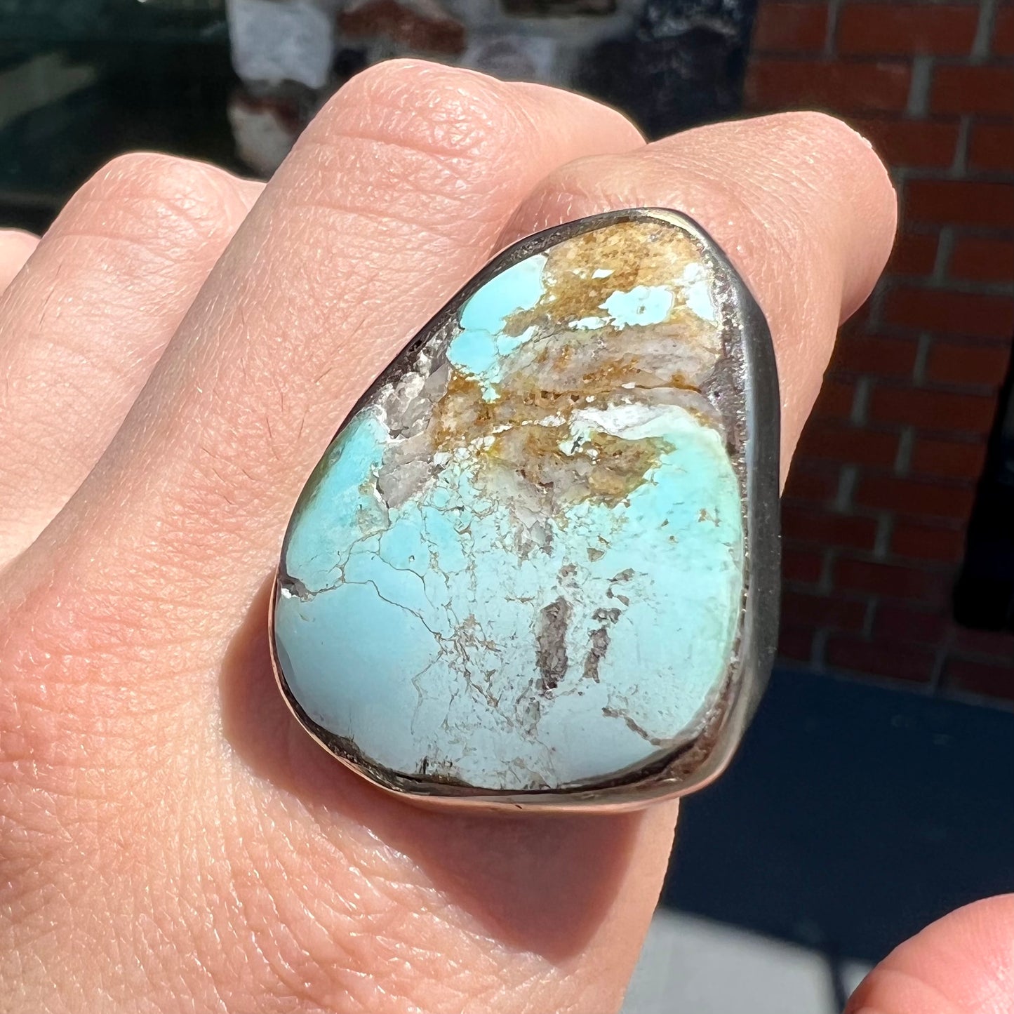 A men's sterling silver ring set with a powder blue turquoise stone. The ring is rustic style.