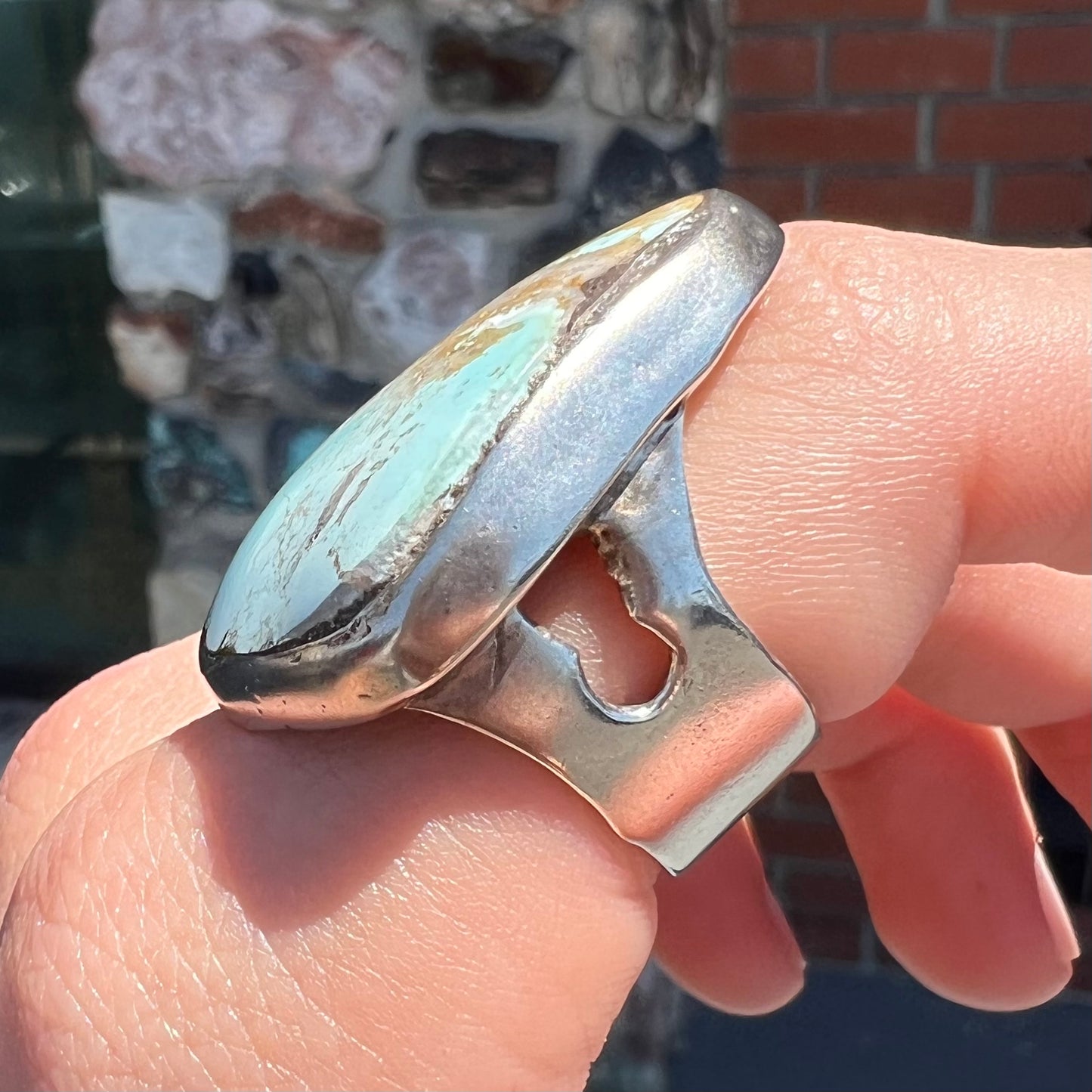 A men's sterling silver ring set with a powder blue turquoise stone. The ring is rustic style.