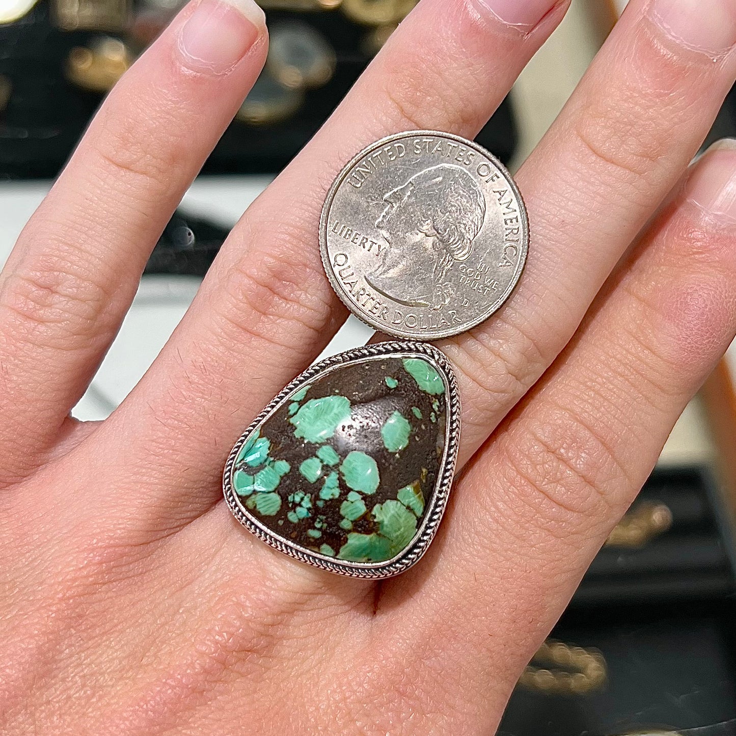 A sterling silver ring bezel set with a green spotted turquoise stone from Carico Lake, Nevada.