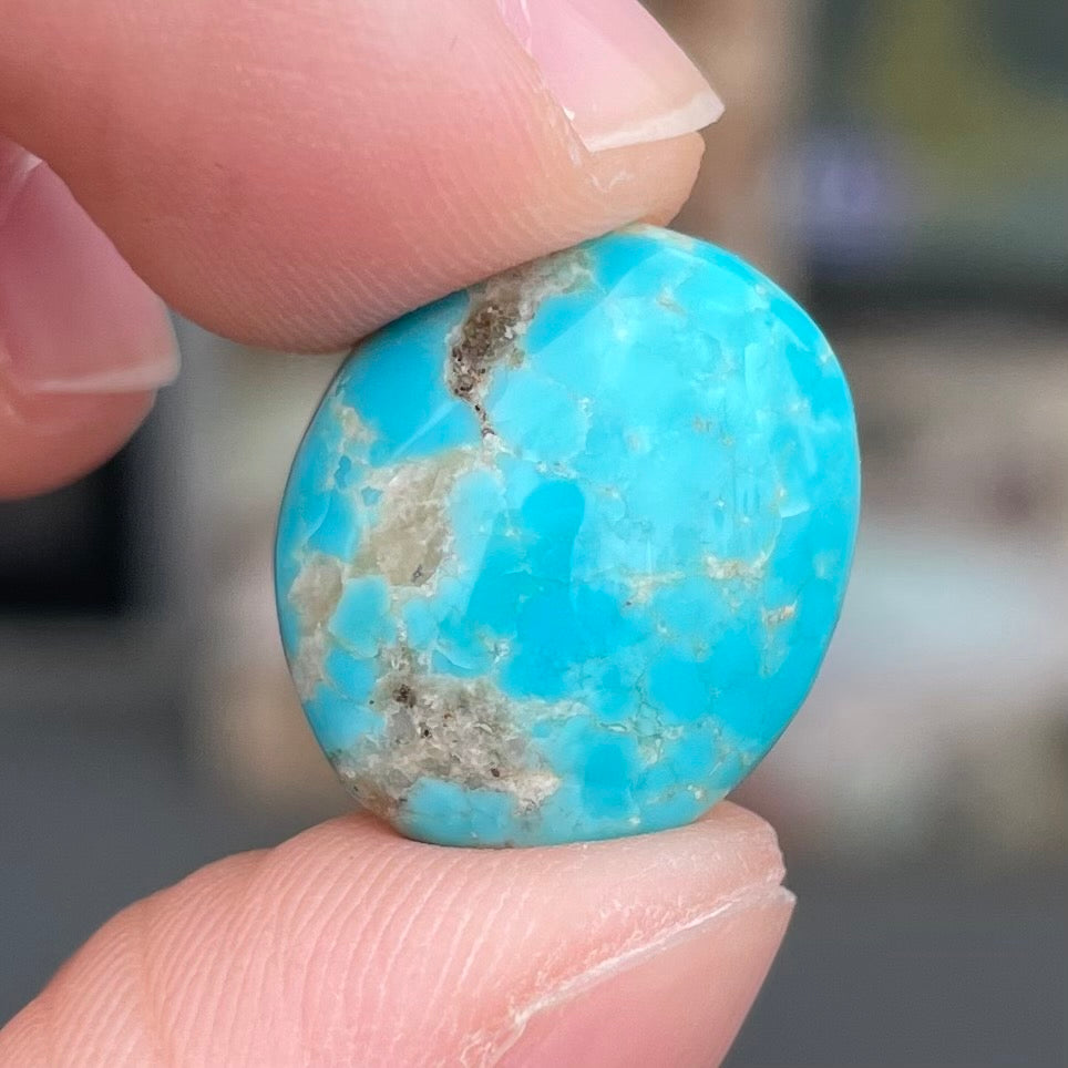 A loose, oval cabochon cut turquoise stone from the Sleeping Beauty Mine in Arizona.