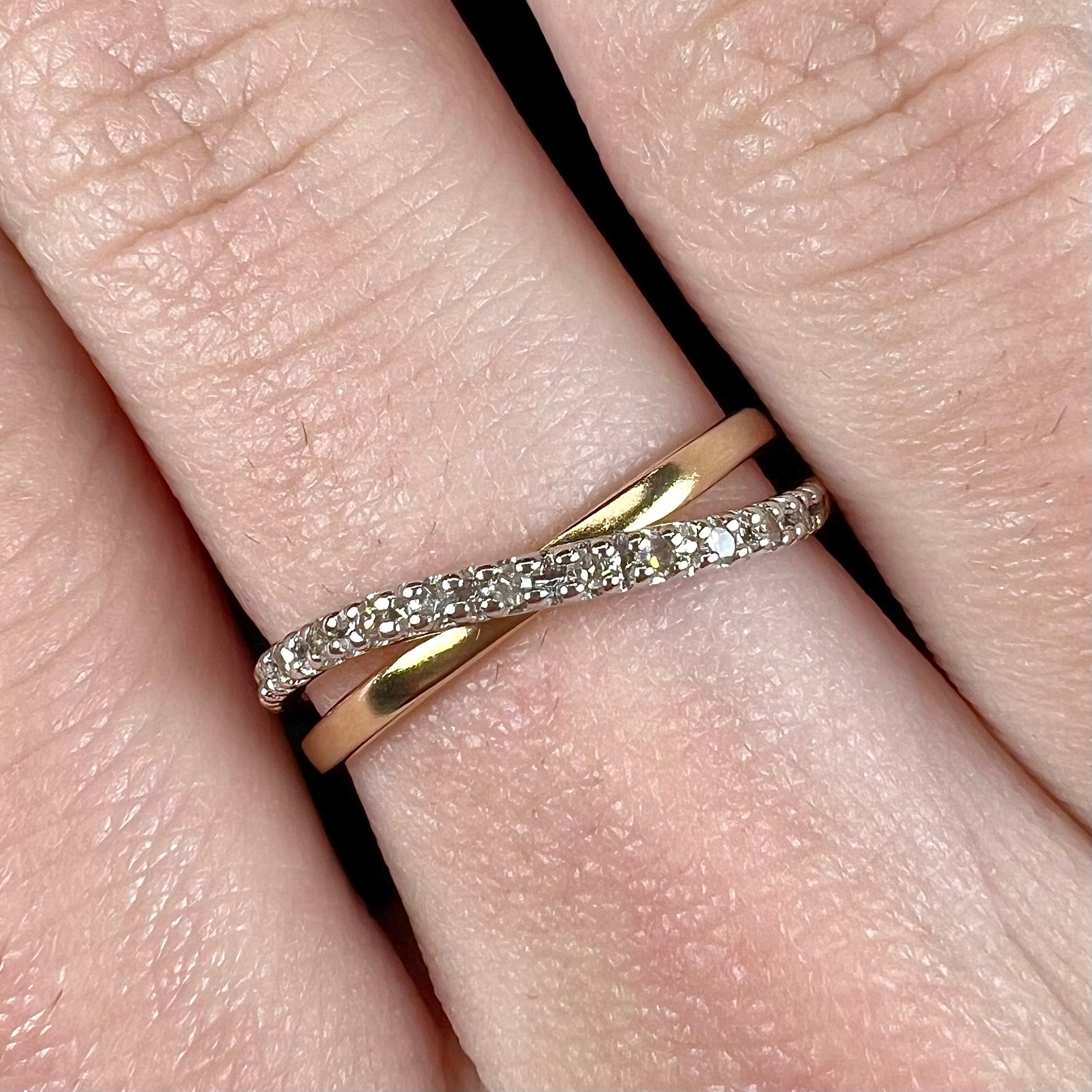 A ladies' two tone yellow and white gold twisted shank ring pave set with round single cut diamonds.