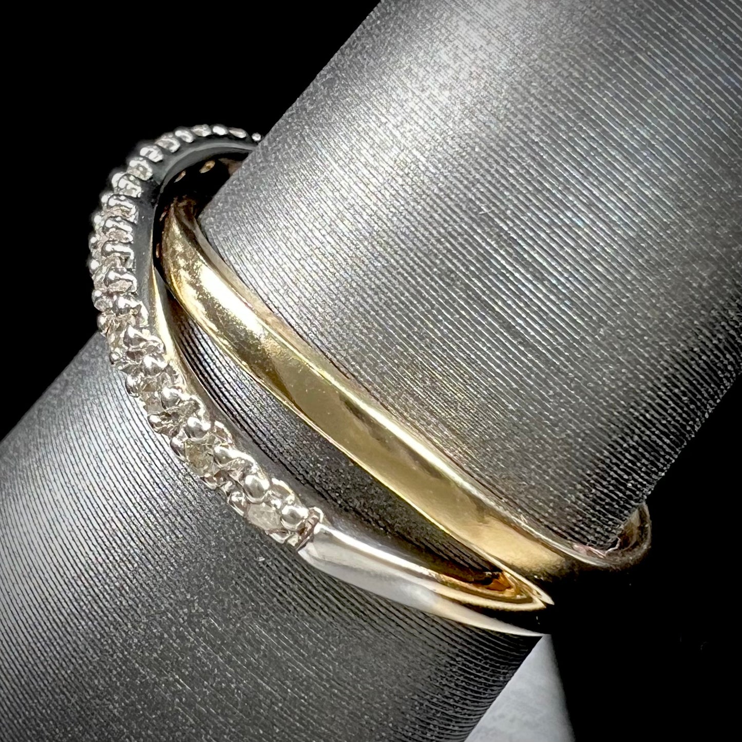 A ladies' two tone yellow and white gold twisted shank ring pave set with round single cut diamonds.