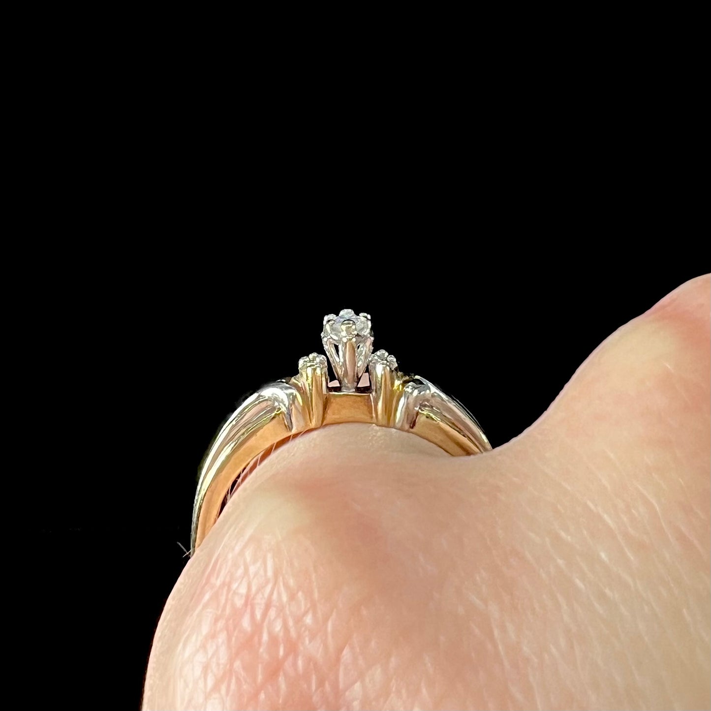 A ladies' two-tone white and yellow gold marquise cut diamond enagagement ring.  There are round diamond accents.