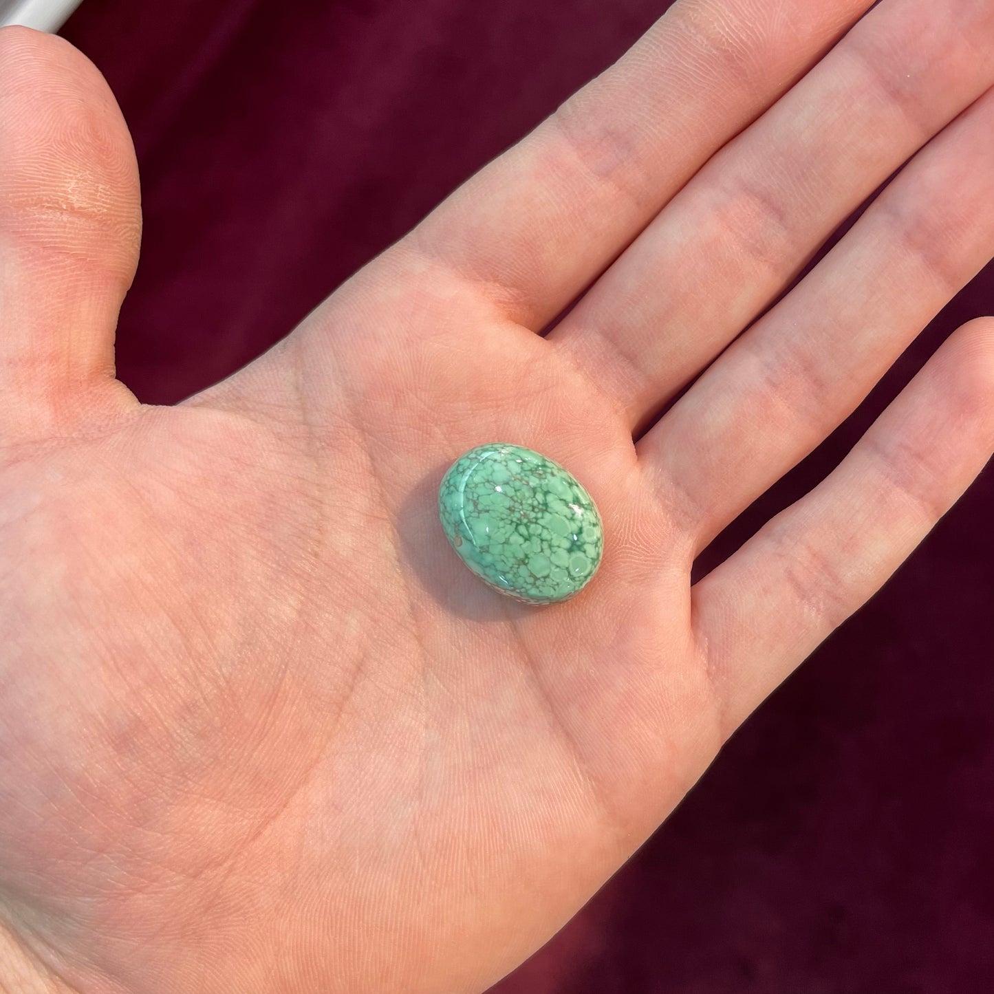 An oval cabochon cut green Variscite stone from Utah, USA.