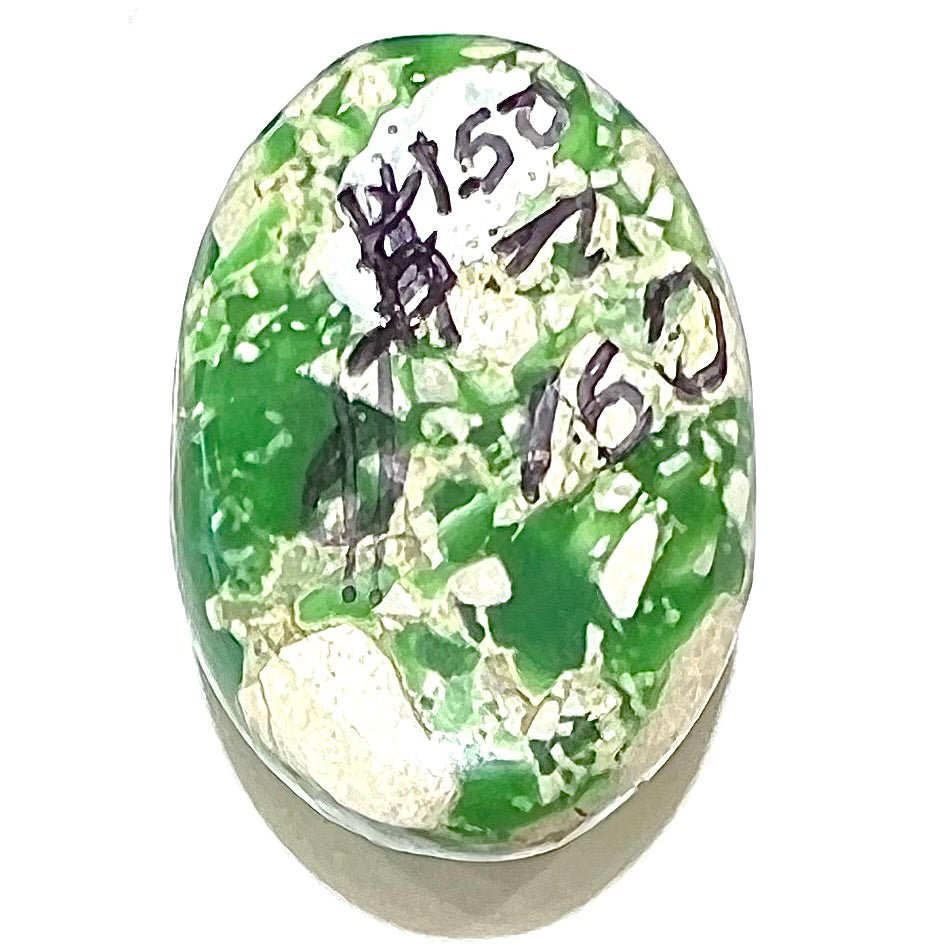 A loose green variscite cabochon from Utah, USA. The price of $150 is written on the back.