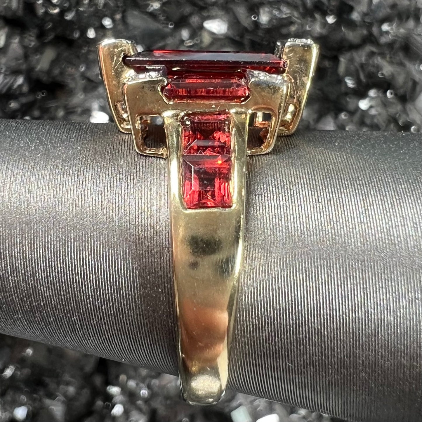 An Art Deco style emerald cut garnet and diamond ring cast in yellow gold.