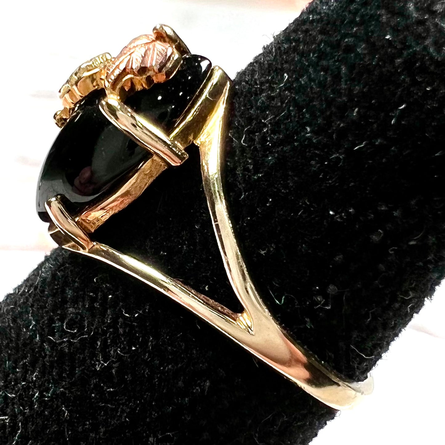 A split shank Black Hills gold ring set with a cabochon marquise cut black onyx.