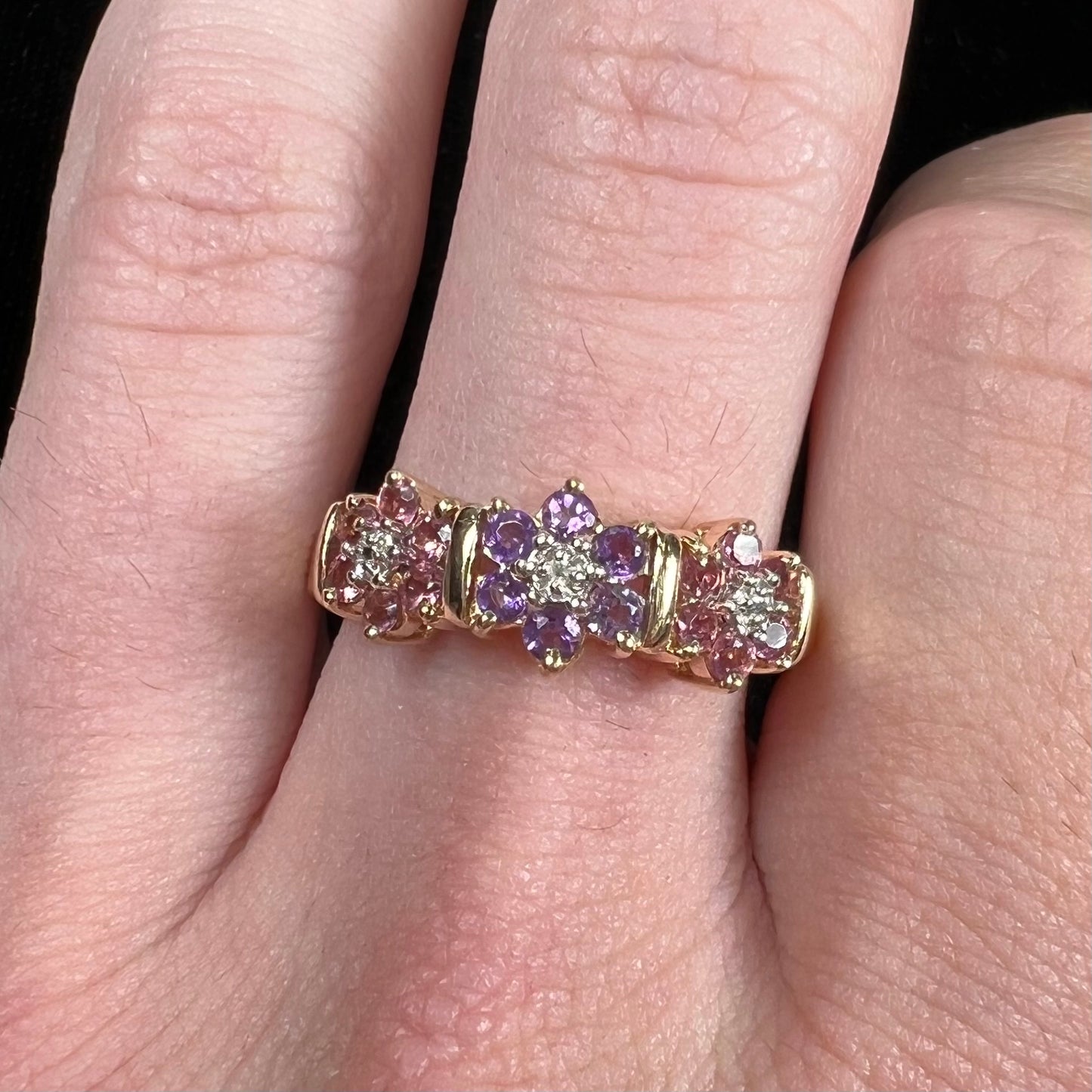 A vintage ladies' flower ring set with set with amethyst and pink tourmaline petals with a diamond center stone.