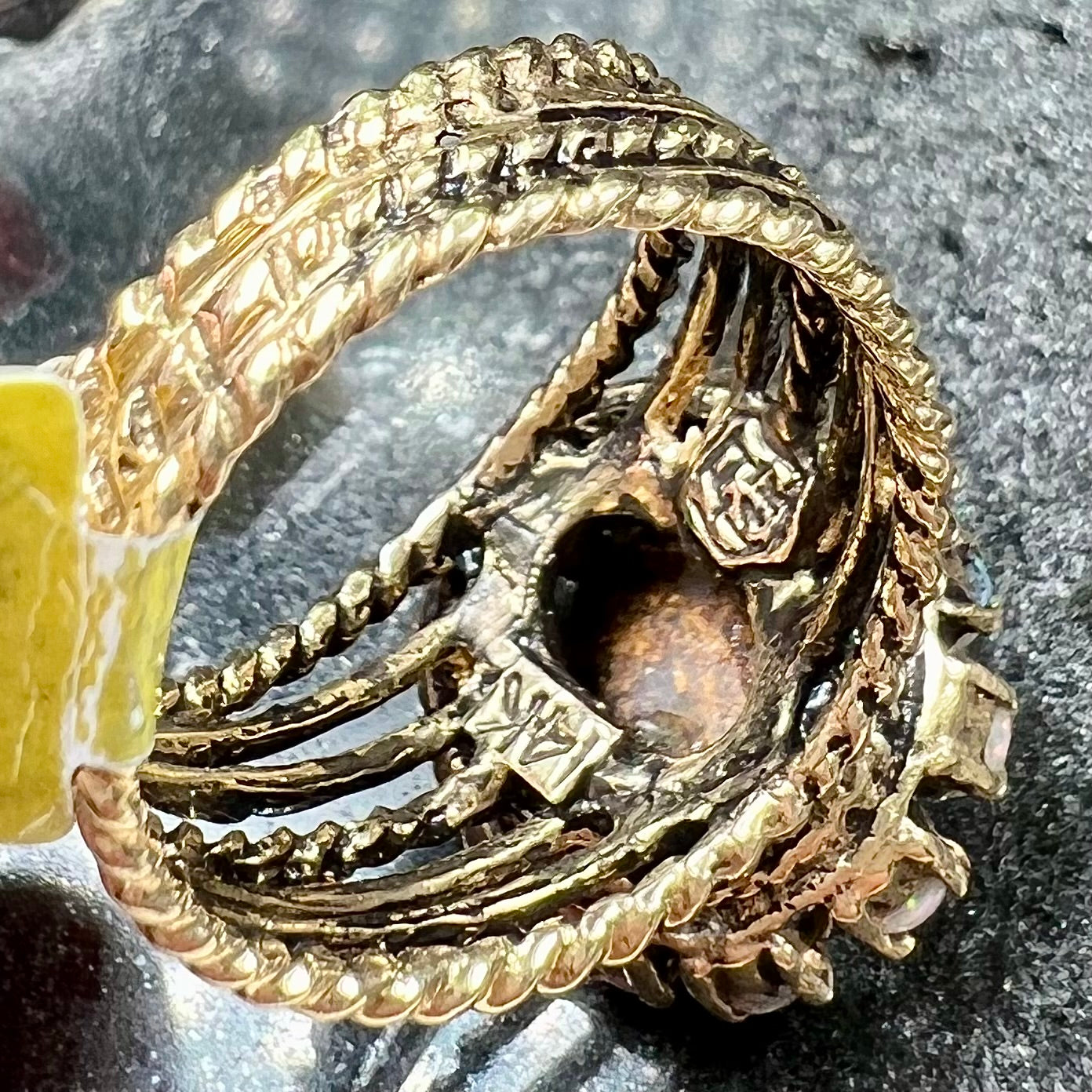 Vintage yellow gold oval opal cabochon ring set with 12 round opals in a halo around the center stone.