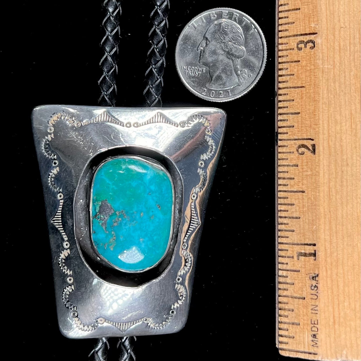 A vintage sterling silver Navajo bolo tie set with Morenci turquoise, handmade by artist Delvin Nelson.
