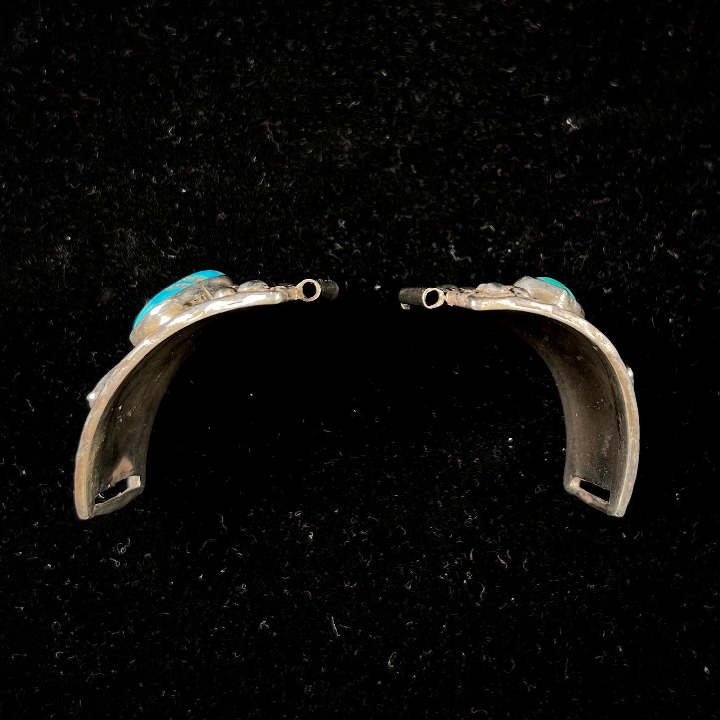 A pair of Navajo made sterling silver watch cuffs set with turquoise and coral stones.