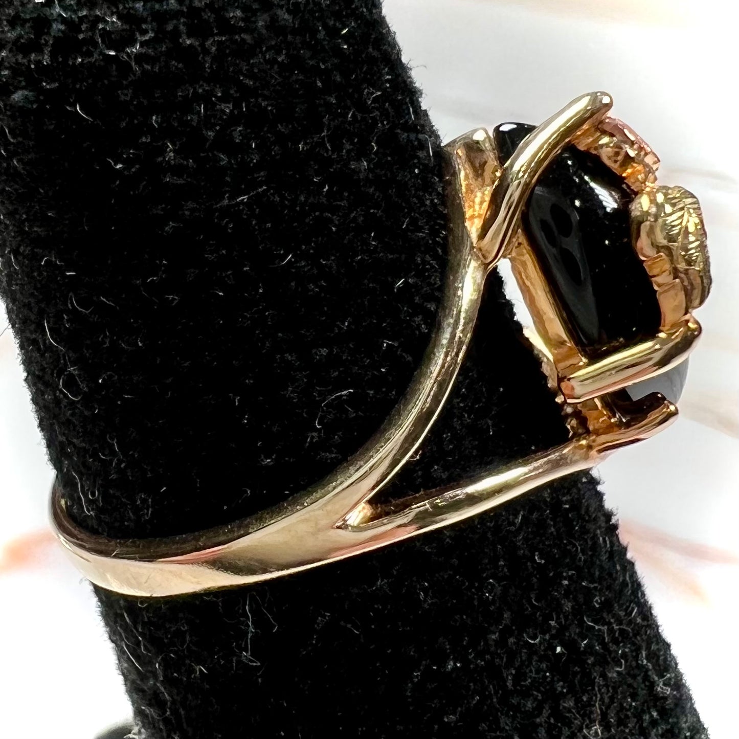 A split shank Black Hills gold ring set with a cabochon marquise cut black onyx.