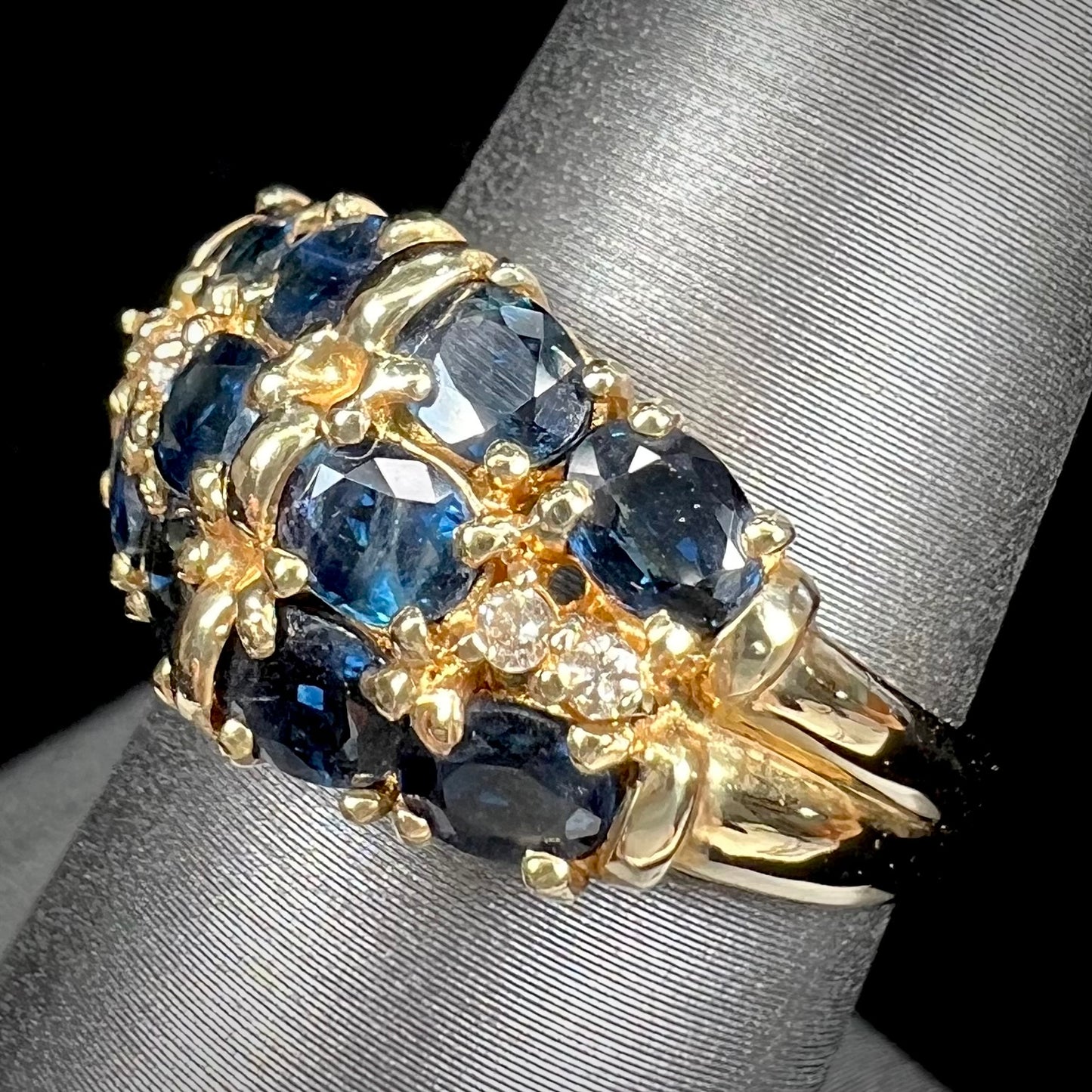 A vintage ladies' blue sapphire and diamond cluster ring cast in yellow gold.