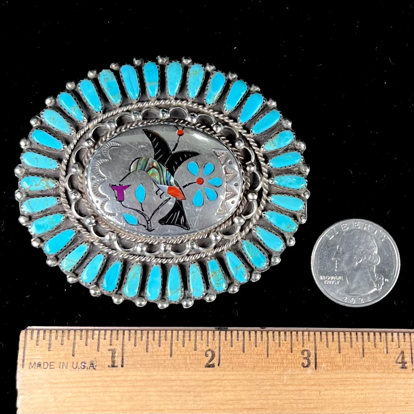 A unisex sterling silver belt buckle featuring the motif of a stone inlaid hummingbird set with petit point turquoise accents, handmade by Navajo artist, Leo G. Harvey.