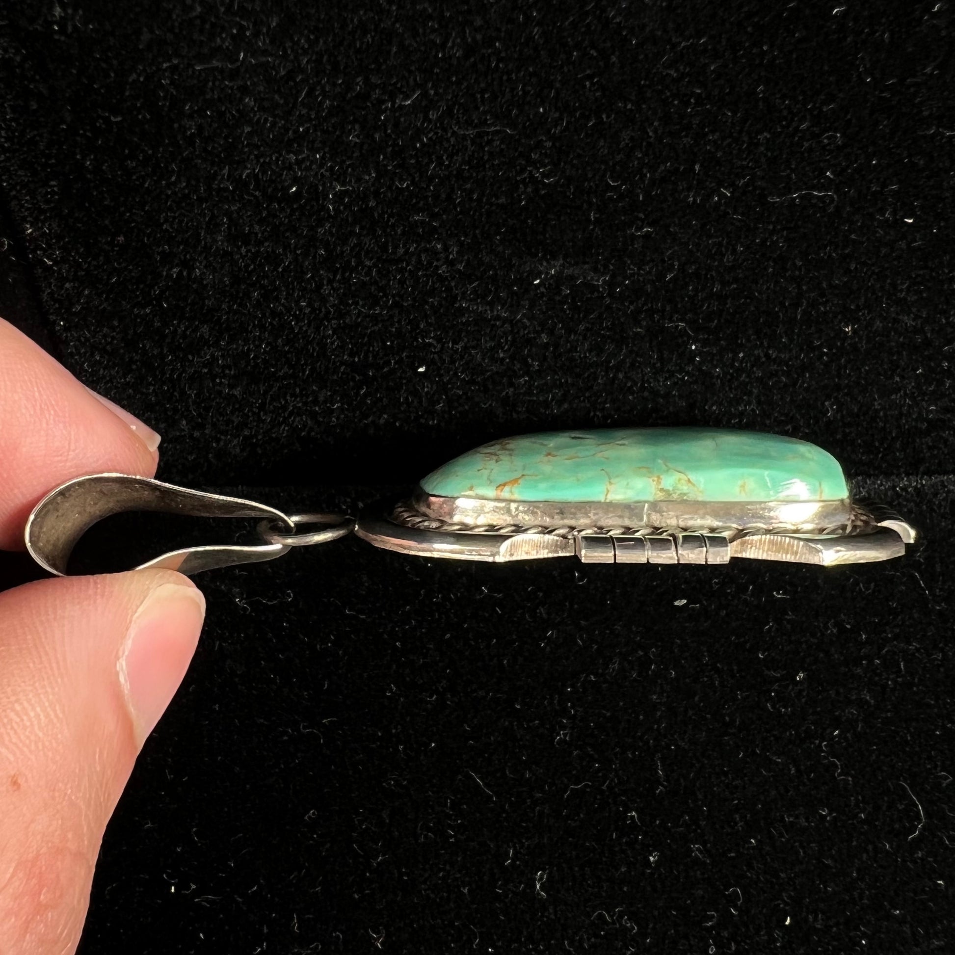 A men's silver Navajo pendant set with a turquoise stone from Pilot Mountain Mine, Nevada.