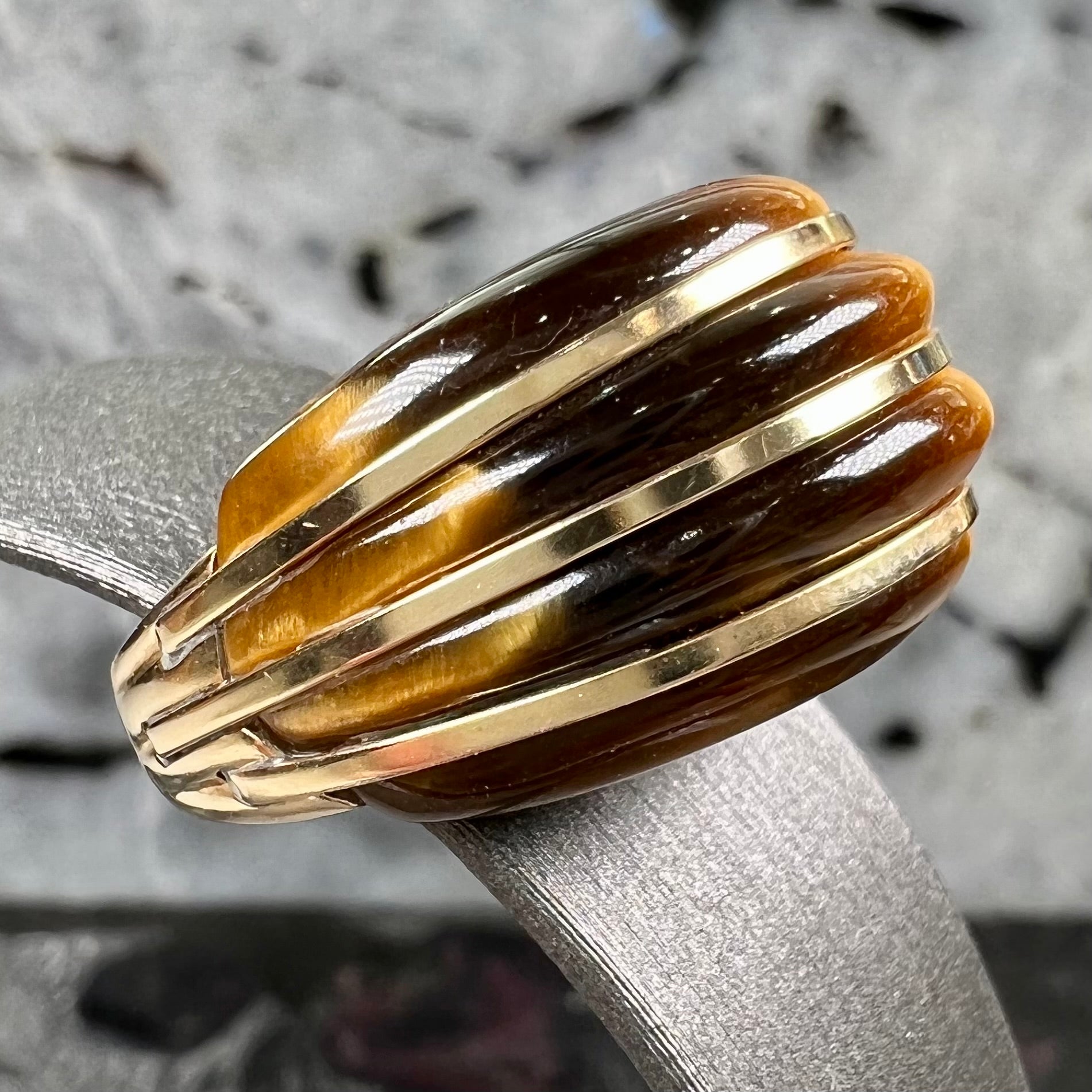 A ladies' high dome carved tiger's eye ring cast in yellow gold.