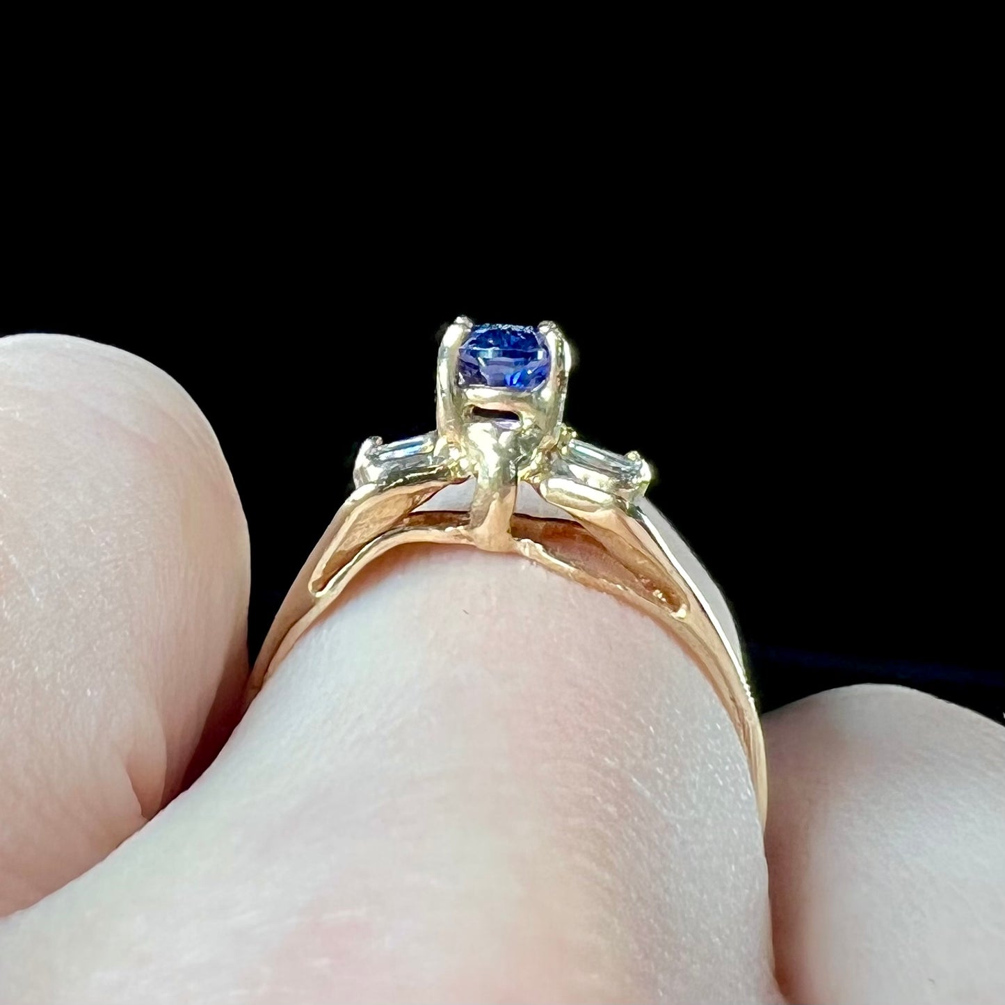 A natural blue sapphire and diamond baguette ring cast in yellow gold.
