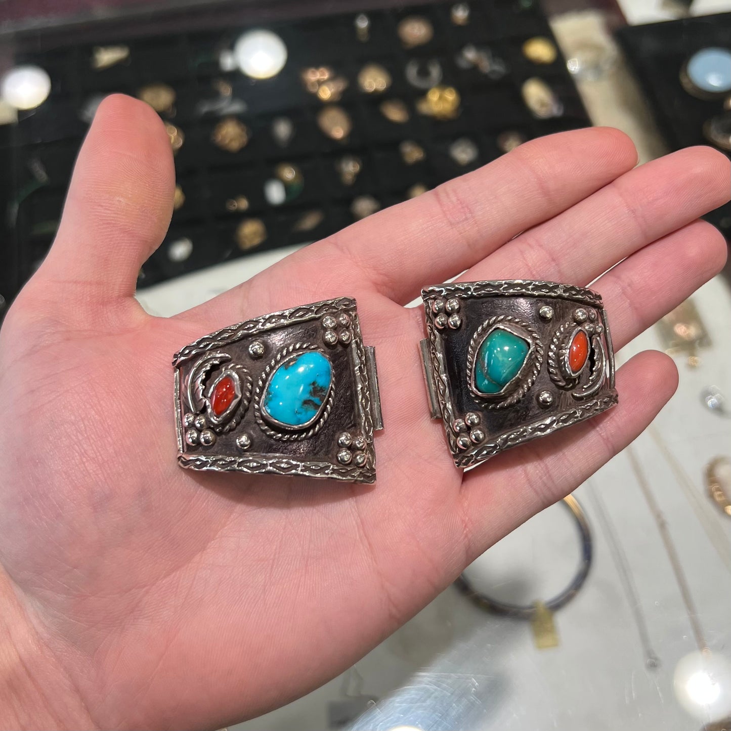 A pair of Navajo made sterling silver watch cuffs set with turquoise and coral stones.