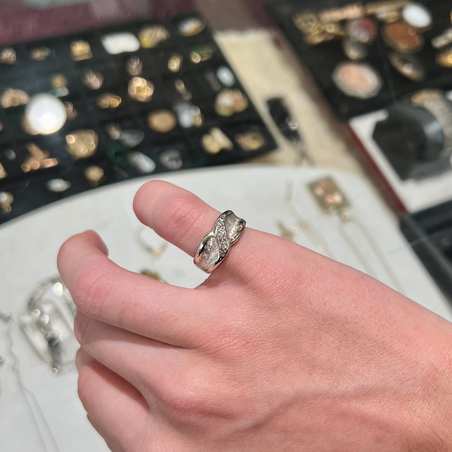 A ladies' white gold five stone single cut diamond ring. The metal of the ring has a textured finish.