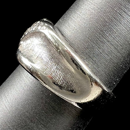 A ladies' white gold five stone single cut diamond ring.  The metal of the ring has a textured finish.