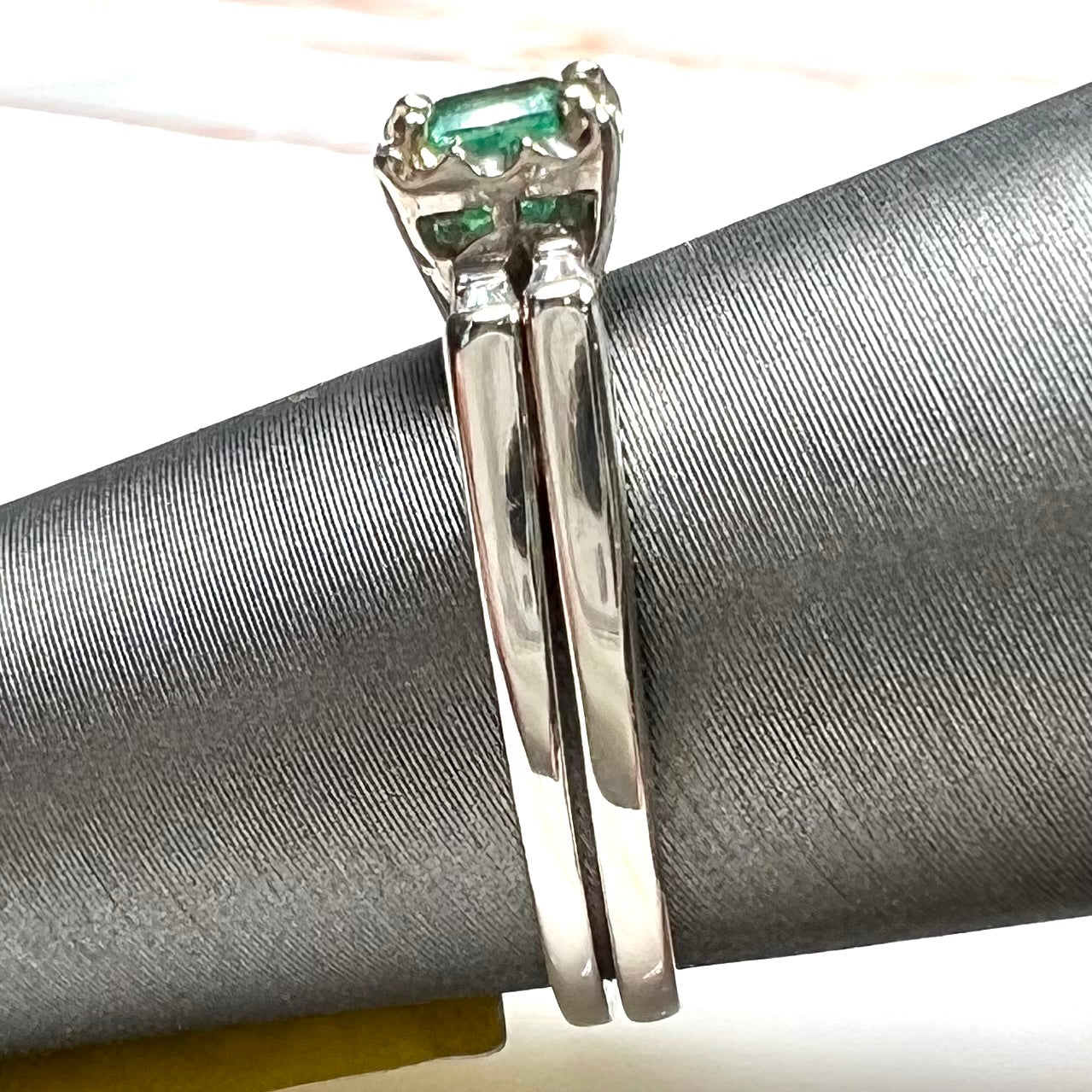 A white gold emerald and baguette cut diamond engagement and wedding set.