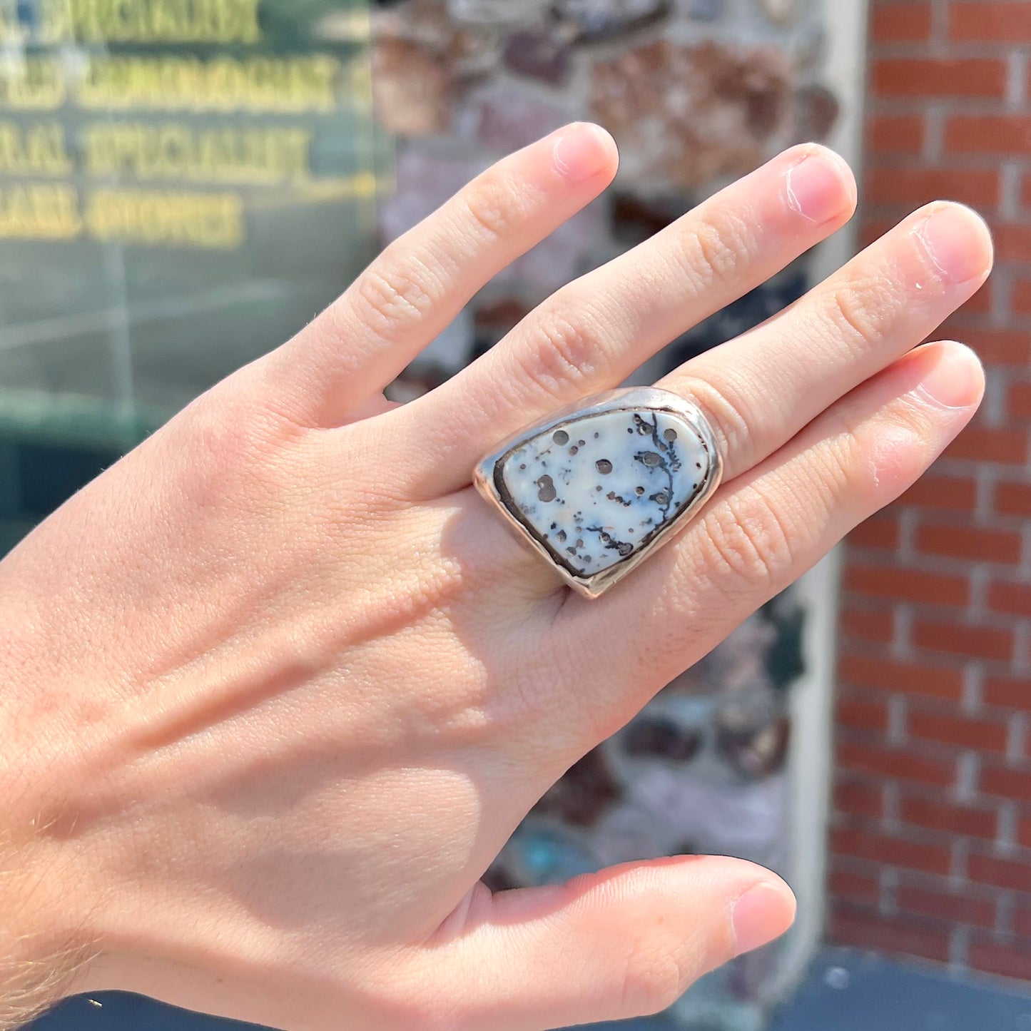 A bezel set ring handmade in sterling silver with a white dendritic agate stone.