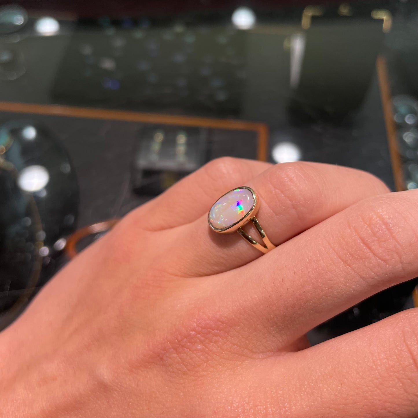 A handmade split shank white opal solitaire ring in yellow gold.