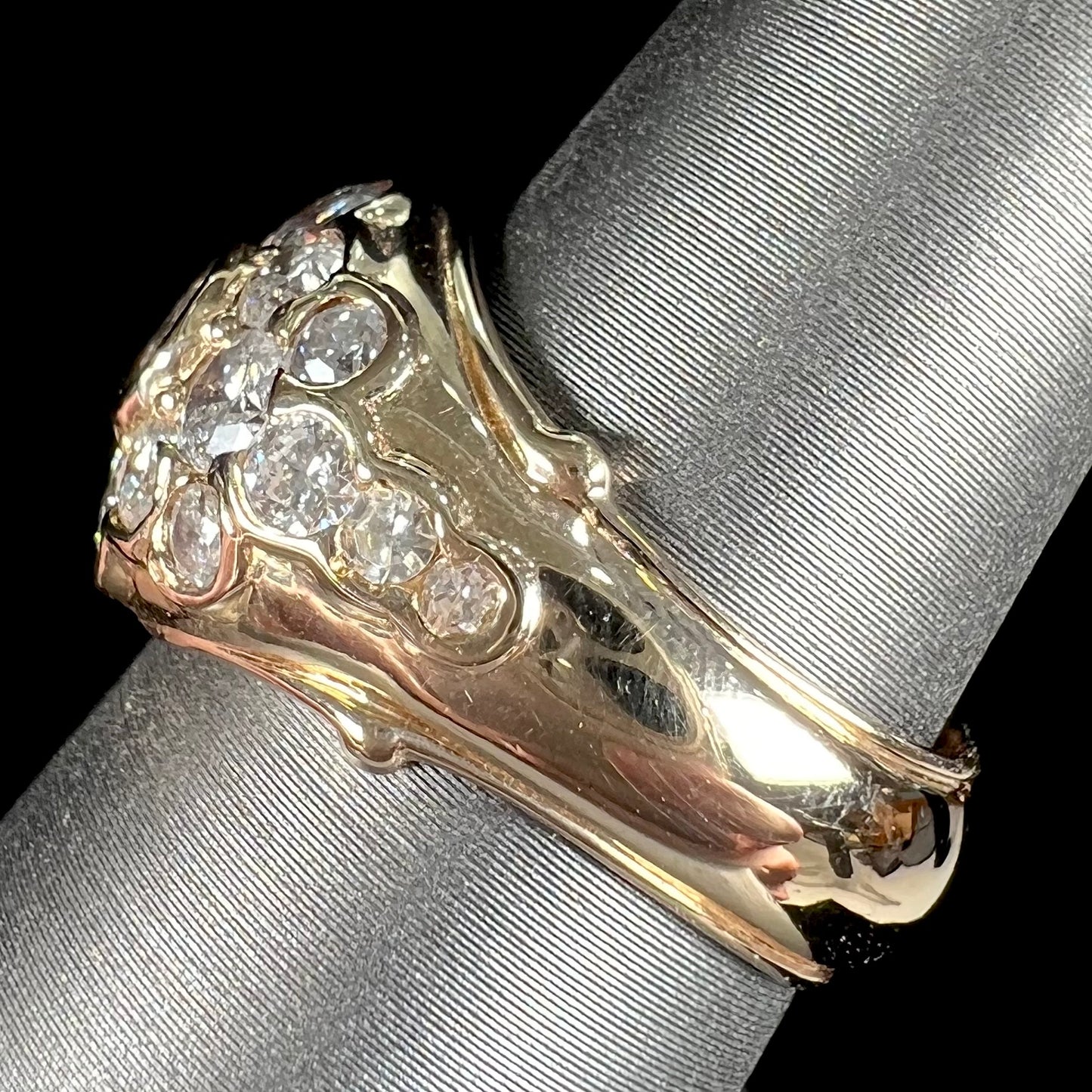 A yellow gold domed diamond ring set with 19 Standard Round Brilliant Cut diamonds.