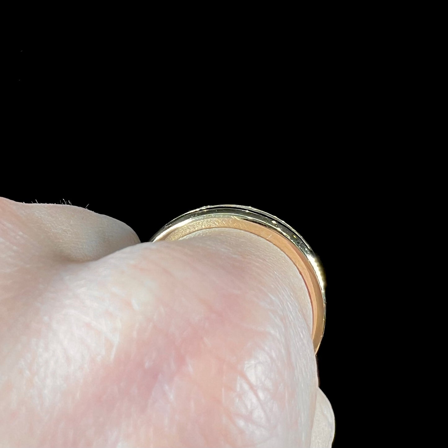 A men's yellow gold channel set diamond wedding band.