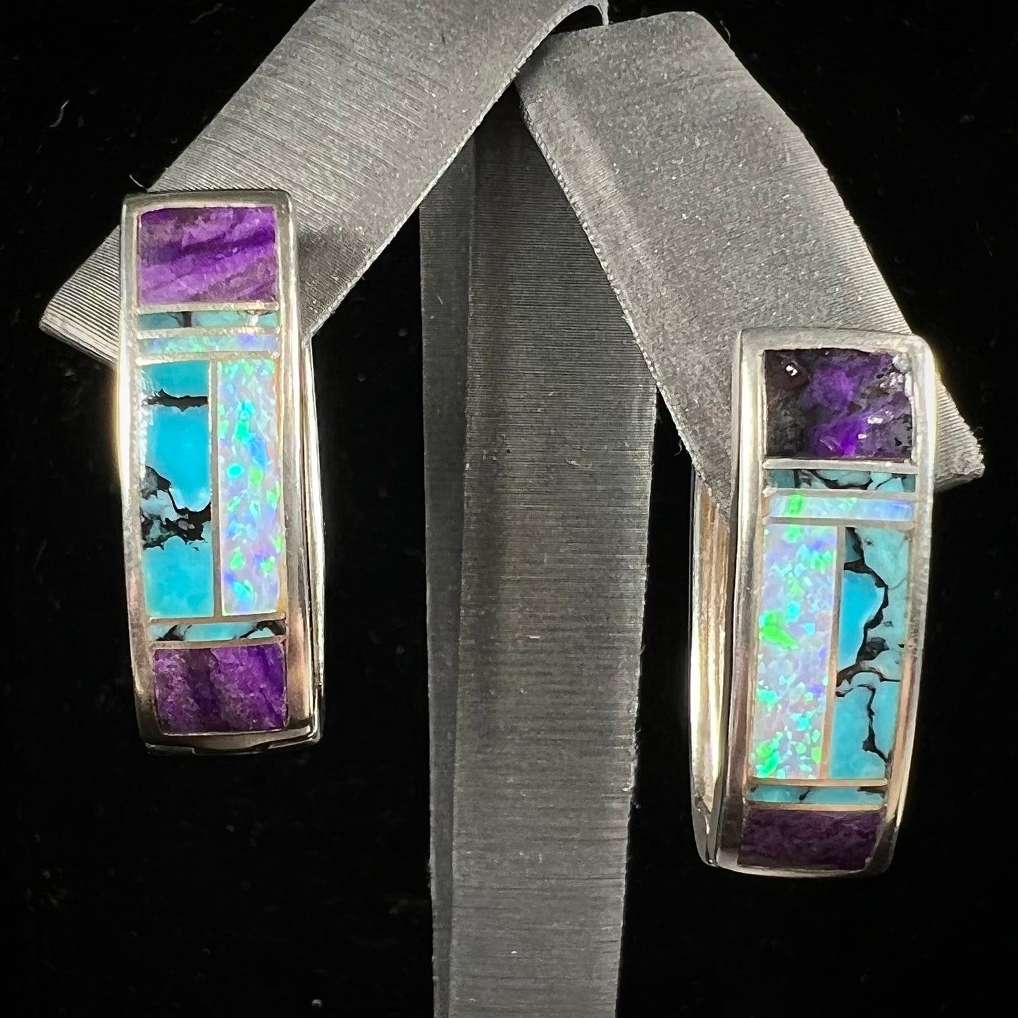 A pair sterling silver inlay earrings set with turquoise, sugilite, and lab created opal stones.