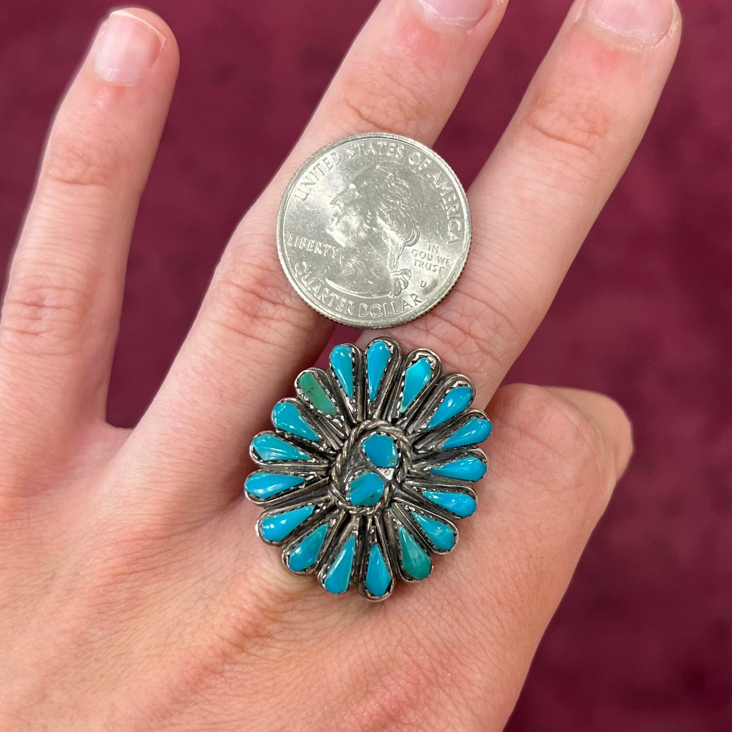 A handmade, sterling silver Zuni Indian ring petit point set with turquoise stones. The ring has a split shank.