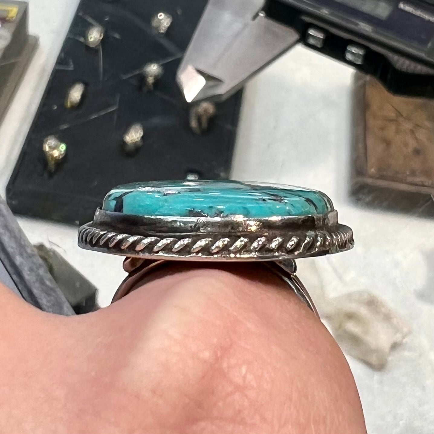 A men's sterling silver ring bezel set with a blue Morenci turquoise. The ring is signed "SAM PIASO".