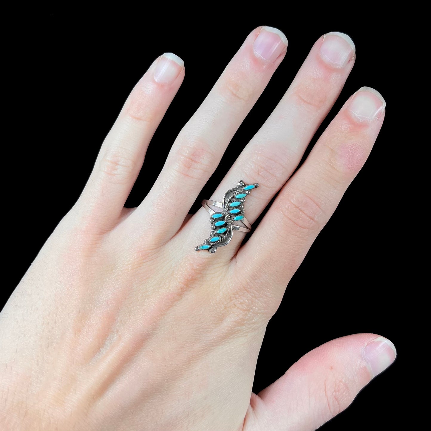 A Zuni needlepoint turquoise ring set in sterling silver.