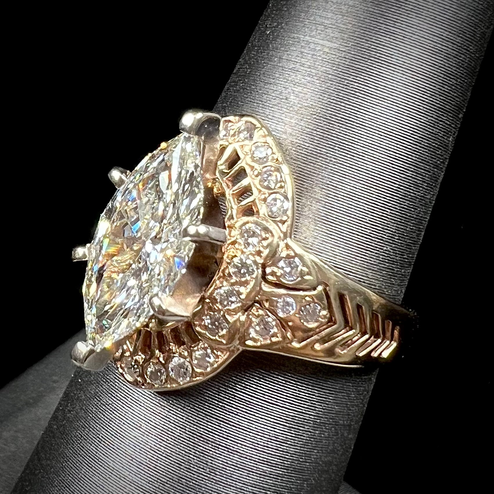 A ladies' yellow gold engagement ring set with a 1.54ct marquise cut natural diamond with round diamond accents.