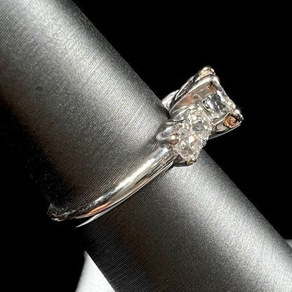 A ladies' 1800's antique white gold diamond ring.  The center stone is an Early American Cut diamond, and the accent stones are Old Mine Cut diamonds.