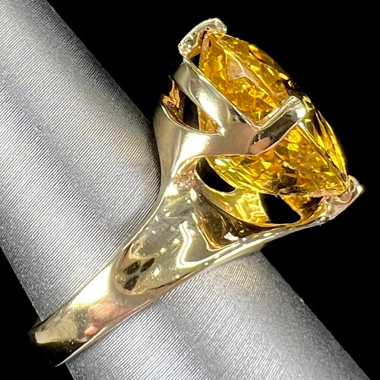 An 18 karat yellow gold solitaire cocktail ring set with a faceted oval cut golden beryl gemstone.