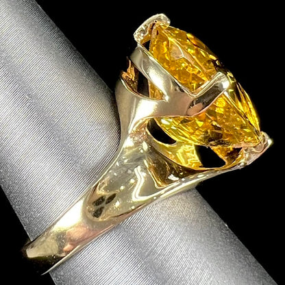An 18 karat yellow gold solitaire cocktail ring set with a faceted oval cut golden beryl gemstone.