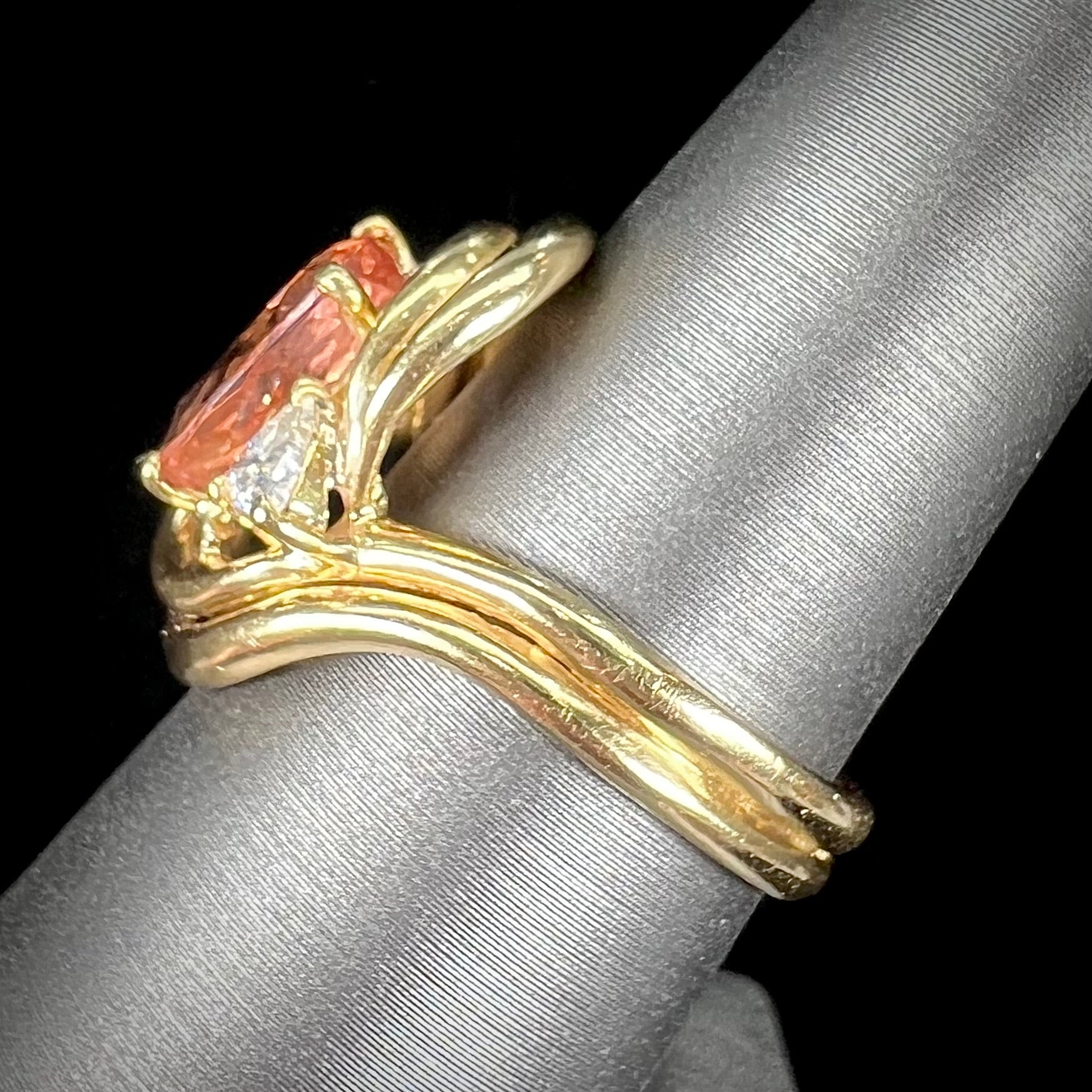 An 18 karat yellow gold ring set with two triangle cut diamonds and a cushion cut imperial topaz.
