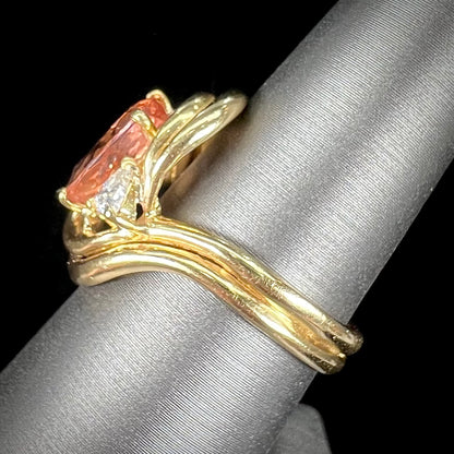 An 18 karat yellow gold ring set with two triangle cut diamonds and a cushion cut imperial topaz.