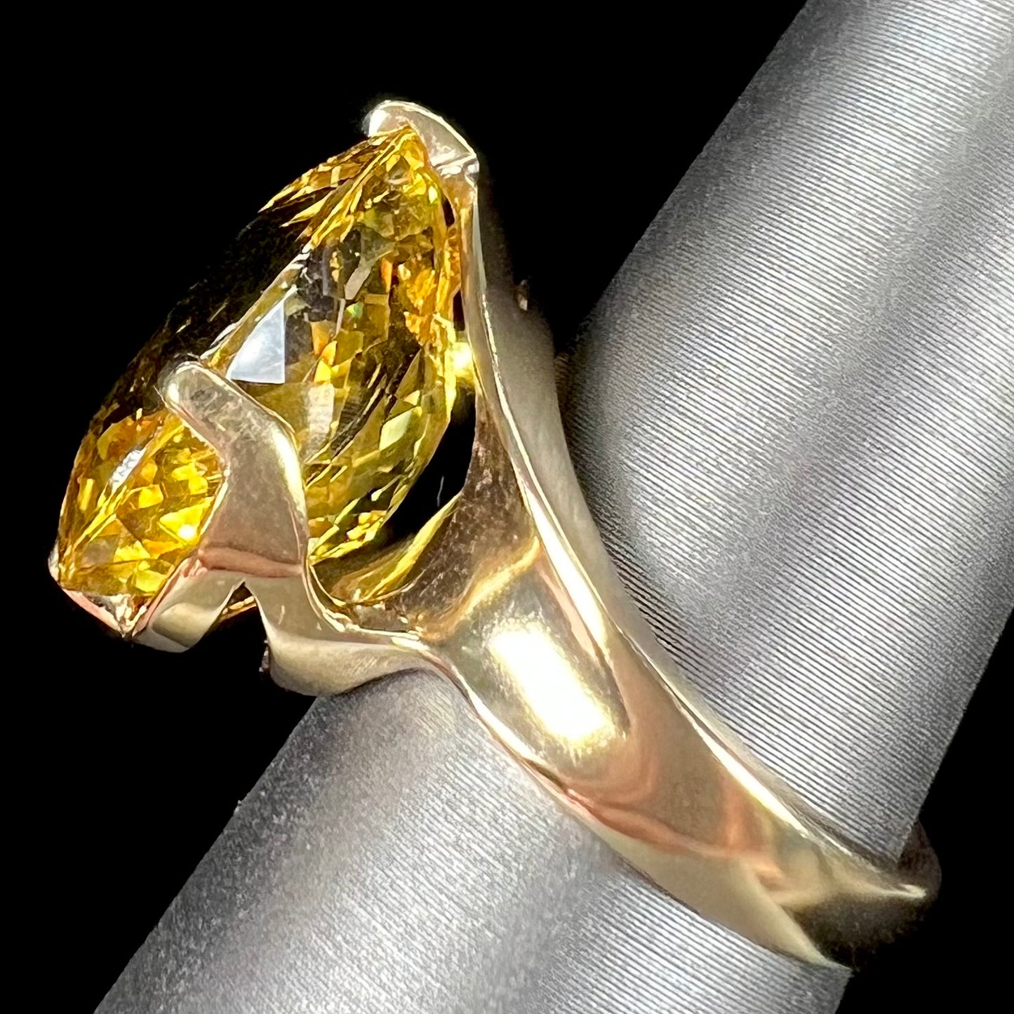 An 18 karat yellow gold solitaire cocktail ring set with a faceted oval cut golden beryl gemstone.