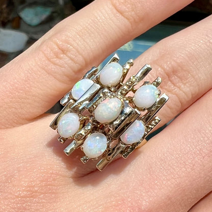 A Mid-Century Modern gold opal cluster ring.  The ring has a tall, tree-like structure and is set with seven natural opals.