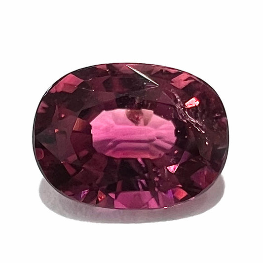 A loose, faceted oval cut purple tourmaline gemstone.  The stone weighs 2.08 carats.
