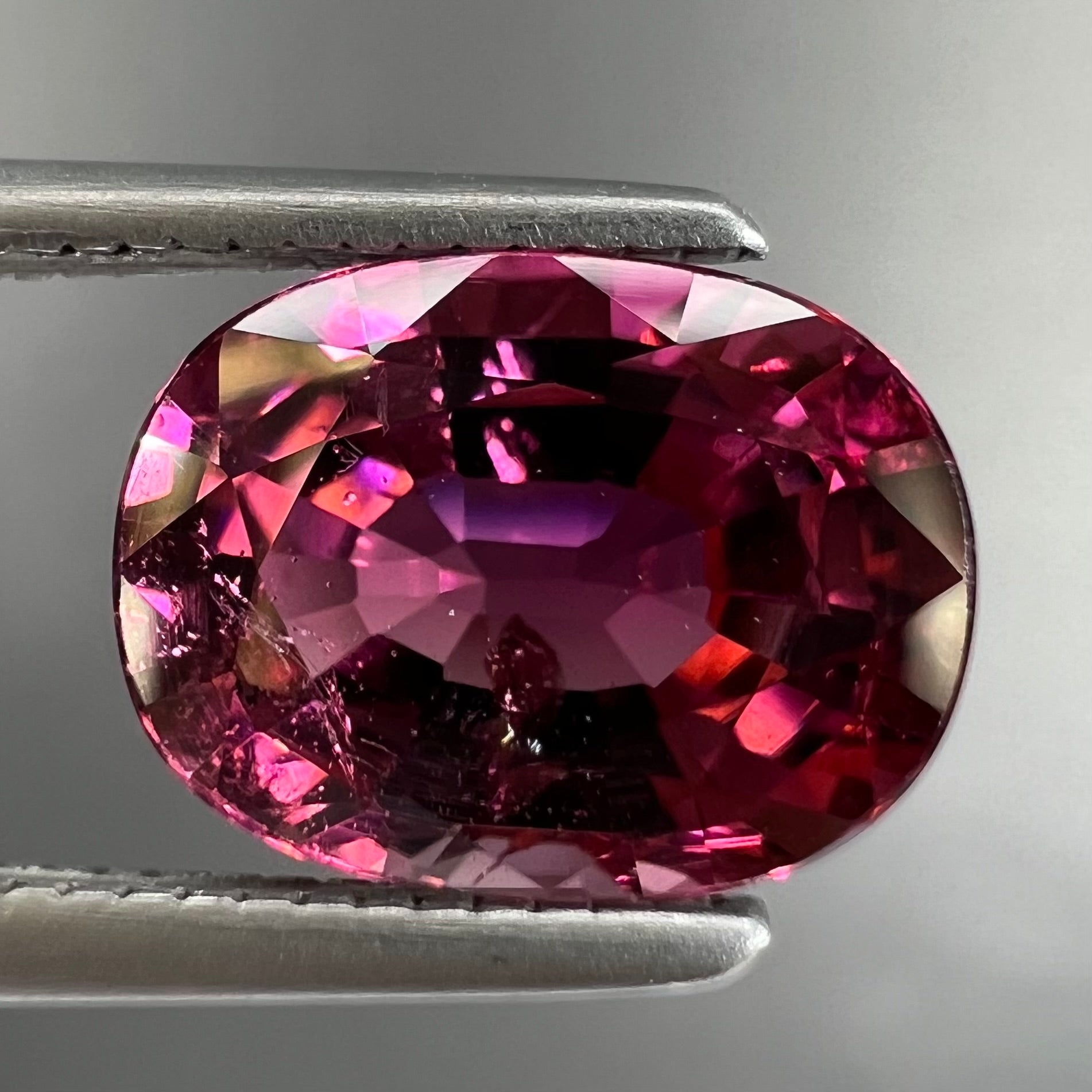 A loose, faceted oval cut purple tourmaline gemstone.  The stone weighs 2.08 carats.