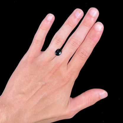 A loose faceted oval cut natural sapphire.  The stone is blue-green color.